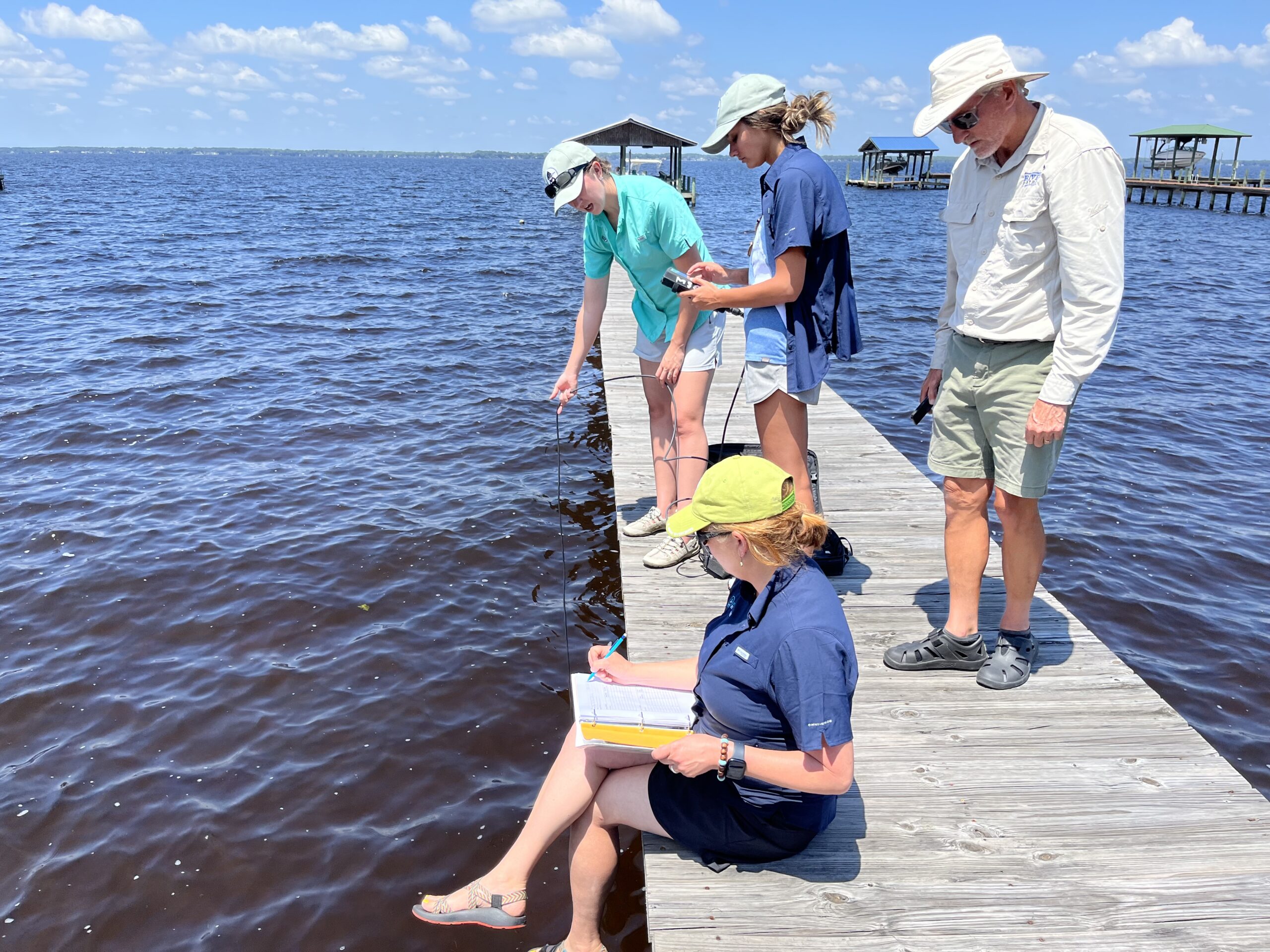 Team talking measurements on a dock in May 2023